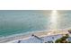 Aerial view of the beach with blue water, white sand, and beachgoers in the distance at 119 Avenida Messina, Sarasota, FL 34242