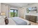 Bright bedroom with a balcony overlooking lush greenery, plus a modern dresser and mounted TV at 119 Avenida Messina, Sarasota, FL 34242