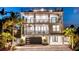 Beautiful beach house at twilight, featuring a spiral staircase and illuminated balconies at 119 Avenida Messina, Sarasota, FL 34242