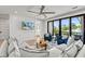 Bright living room with access to a balcony offering city views, comfortable sofa, and ceiling fan at 119 Avenida Messina, Sarasota, FL 34242