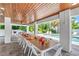 Inviting covered patio with long table, white chairs, and a view of the sparkling pool, perfect for outdoor entertaining at 119 Avenida Messina, Sarasota, FL 34242