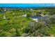 Scenic aerial shot featuring lush landscape, homes and a tranquil pond, embodying serene waterfront living at 1230 Bayshore Dr, Terra Ceia, FL 34250