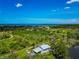 Aerial view of neighborhood with waterfront views, lush landscape, and clear blue skies at 1230 Bayshore Dr, Terra Ceia, FL 34250