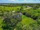 Overhead view of lush greenery surrounding a cozy home, enveloped by mature trees and a well-maintained green yard at 1230 Bayshore Dr, Terra Ceia, FL 34250