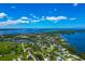 Elevated view of a waterfront community with quaint houses, green spaces, and calm waterways under a partly cloudy sky at 1230 Bayshore Dr, Terra Ceia, FL 34250