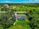 Aerial view of home with lush lawn, mature trees and privacy fencing, highlighting the property's appeal at 1230 Bayshore Dr, Terra Ceia, FL 34250