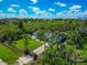 Aerial view of home featuring a small yard, mature landscaping, damage to roof covered by tarp, and fenced yard at 1230 Bayshore Dr, Terra Ceia, FL 34250