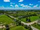 Expansive aerial view of a lush landscape featuring mature palm trees, a paved road, and waterfront views with a bright blue sky at 1230 Bayshore Dr, Terra Ceia, FL 34250