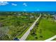 Aerial view of neighborhood featuring a street lined with palm trees at 1230 Bayshore Dr, Terra Ceia, FL 34250