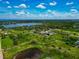 Scenic community view featuring lush green landscapes, a pond, and a lake under a partly cloudy blue sky at 1230 Bayshore Dr, Terra Ceia, FL 34250