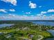 Open expanse of green land with serene water views, dotted with clusters of homes and mature trees and a blue sky at 1230 Bayshore Dr, Terra Ceia, FL 34250