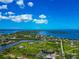 Expansive aerial view featuring waterfront properties, tranquil waterways, and a lush green environment under a vibrant sky at 1230 Bayshore Dr, Terra Ceia, FL 34250