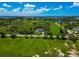 Lovely aerial scene of a lush landscape with a small home, palm trees lining the road, and water views under a blue sky at 1230 Bayshore Dr, Terra Ceia, FL 34250