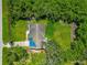 Aerial view showcases a house with mature trees and a lush lawn, offering privacy and a natural setting at 1230 Bayshore Dr, Terra Ceia, FL 34250