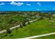 Aerial view showcases a green property with a roadside view, lush trees, and the expansive beauty of the surrounding landscape at 1230 Bayshore Dr, Terra Ceia, FL 34250