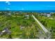 Picturesque aerial view showcasing lush green fields, a road, and a serene waterfront community on a clear day at 1230 Bayshore Dr, Terra Ceia, FL 34250