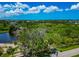 Scenic aerial view showcasing the lush, green landscape surrounding a home with mature trees and a nearby pond at 1230 Bayshore Dr, Terra Ceia, FL 34250