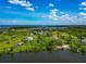 Scenic landscape showcasing homes, ponds, and lush greenery with a clear, blue waterfront in the distance under a partly cloudy sky at 1230 Bayshore Dr, Terra Ceia, FL 34250