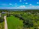 Wide aerial shot of lush community showcasing green spaces and homes near the water at 1230 Bayshore Dr, Terra Ceia, FL 34250