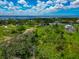 Aerial view of waterfront properties nestled among lush greenery with serene ponds and expansive water views at 1230 Bayshore Dr, Terra Ceia, FL 34250