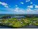 Breathtaking aerial view of waterfront neighborhood with scattered homes nestled among green landscapes and blue waters under a cloudy sky at 1230 Bayshore Dr, Terra Ceia, FL 34250