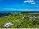 Aerial scenery capturing waterfront homes nestled among trees and ponds with captivating water backdrop at 1230 Bayshore Dr, Terra Ceia, FL 34250