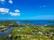Stunning aerial showcasing waterfront homes surrounded by lush greenery, ponds, and open water views at 1230 Bayshore Dr, Terra Ceia, FL 34250