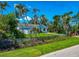 Home featuring a small yard, mature landscaping, fenced yard, and damage to roof covered by tarp at 1230 Bayshore Dr, Terra Ceia, FL 34250