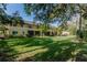 Beautiful backyard view featuring lush greenery, a well-maintained lawn, and the rear of the building at 13084 Tigers Eye Dr, Venice, FL 34292