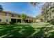 Scenic backyard view showcasing a lush lawn, the building's rear facade, and vibrant green trees at 13084 Tigers Eye Dr, Venice, FL 34292