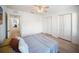 Well-lit bedroom features neutral paint, wood-look floors, ceiling fan, and double closets at 13084 Tigers Eye Dr, Venice, FL 34292