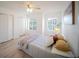 Bright bedroom features wood-look floors, ceiling fan, and natural light from two windows at 13084 Tigers Eye Dr, Venice, FL 34292