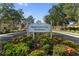 Entrance sign for Stoneywood Cove Townhomes, surrounded by colorful landscaping and mature trees at 13084 Tigers Eye Dr, Venice, FL 34292