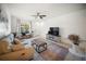 Bright living room features a comfortable sofa, stylish rug, and a ceiling fan at 13084 Tigers Eye Dr, Venice, FL 34292