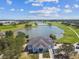 Scenic aerial view of the community clubhouse overlooking the lake and golf course at 1415 Millbrook Cir, Bradenton, FL 34212