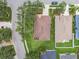 Aerial view of a well-maintained home with a brown roof, green lawn, and mature trees at 1415 Millbrook Cir, Bradenton, FL 34212