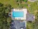 Aerial view of community pool with lounge chairs, tables, and surrounding lush landscaping at 1415 Millbrook Cir, Bradenton, FL 34212