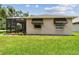 Back of a home showcasing a screened-in porch and manicured lawn at 1415 Millbrook Cir, Bradenton, FL 34212