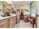 Elegant bathroom with tiled shower, double vanity, and seating area by the window at 1415 Millbrook Cir, Bradenton, FL 34212