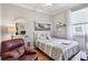 Cozy bedroom with a full bed, decorative painting and white wicker vanity desk at 1415 Millbrook Cir, Bradenton, FL 34212