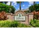 Entrance to the 'Millbrook' community, featuring a brick sign surrounded by lush, colorful landscaping at 1415 Millbrook Cir, Bradenton, FL 34212