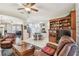Elegant dining room with chandelier, glass table, floral decor, and black grand piano in adjacent living area at 1415 Millbrook Cir, Bradenton, FL 34212