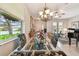 Dining room featuring chandelier, glass table, floral decor, and piano view at 1415 Millbrook Cir, Bradenton, FL 34212