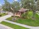 Charming single-Gathering home featuring a well-manicured lawn, lovely landscaping, and a brick-paved front patio at 1415 Millbrook Cir, Bradenton, FL 34212