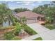Beautifully landscaped single-Gathering home with well-maintained lawn, mature trees, and spacious driveway at 1415 Millbrook Cir, Bradenton, FL 34212
