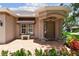 Welcoming front entrance with stone bench, decorative awning, and lush plantings at 1415 Millbrook Cir, Bradenton, FL 34212