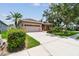 Well-maintained home with a two-car garage, mature trees, and lush green lawn at 1415 Millbrook Cir, Bradenton, FL 34212