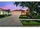 Charming single-story home featuring a two-car garage, manicured lawn, and colorful landscaping at 1415 Millbrook Cir, Bradenton, FL 34212