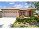 Inviting home with a two-car garage, landscaped garden, and covered entrance at 1415 Millbrook Cir, Bradenton, FL 34212