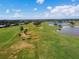 Scenic aerial view of the golf course showing the green, lake, and surrounding landscape at 1415 Millbrook Cir, Bradenton, FL 34212